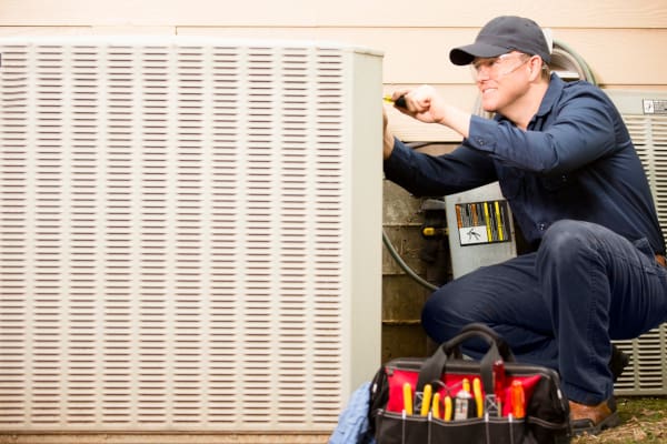 An HVAC tech working on an AC unit